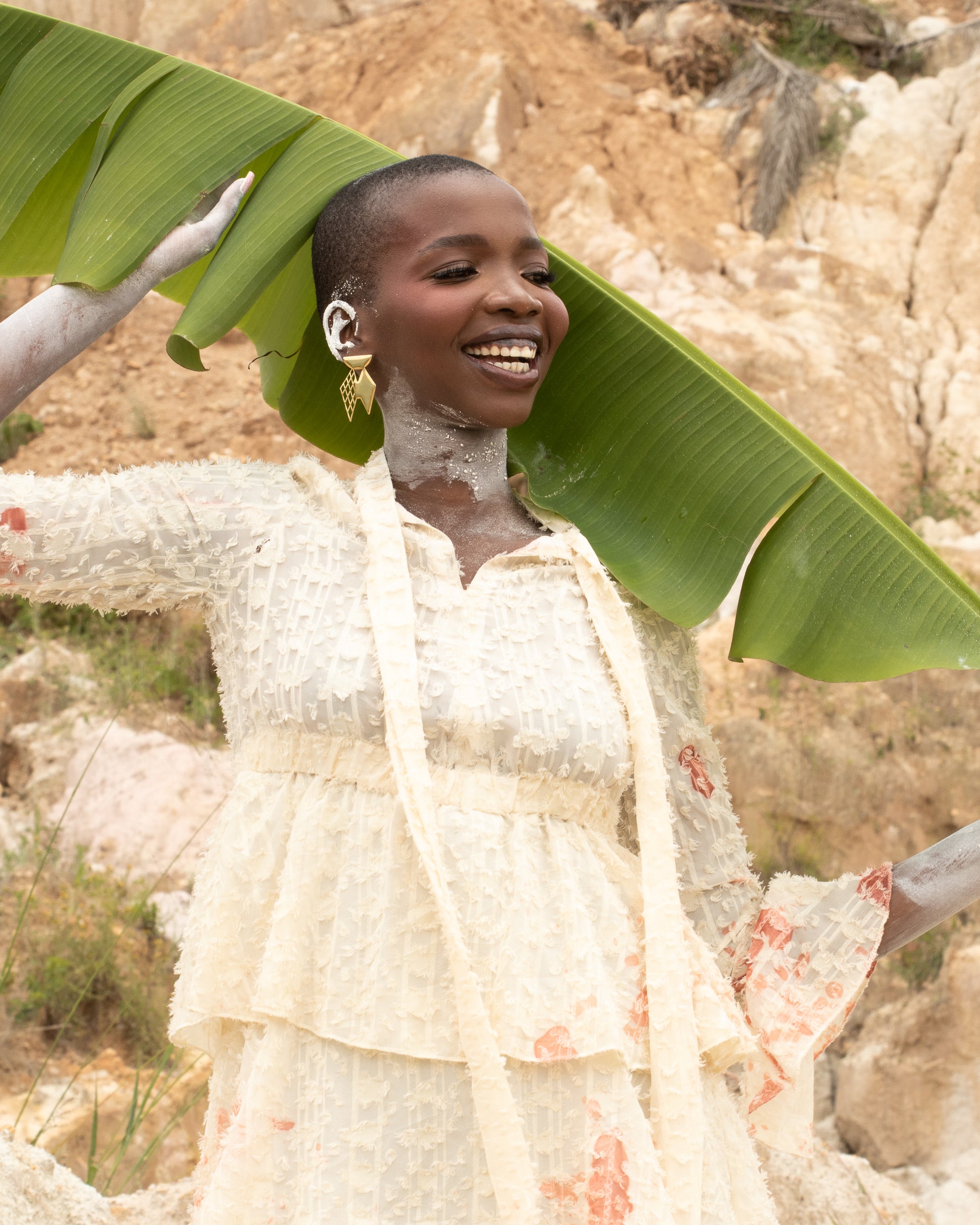 Model wearing EFA earrings,gold plated earrings shaped like a rhombus; 2 rhombus held with a moon.