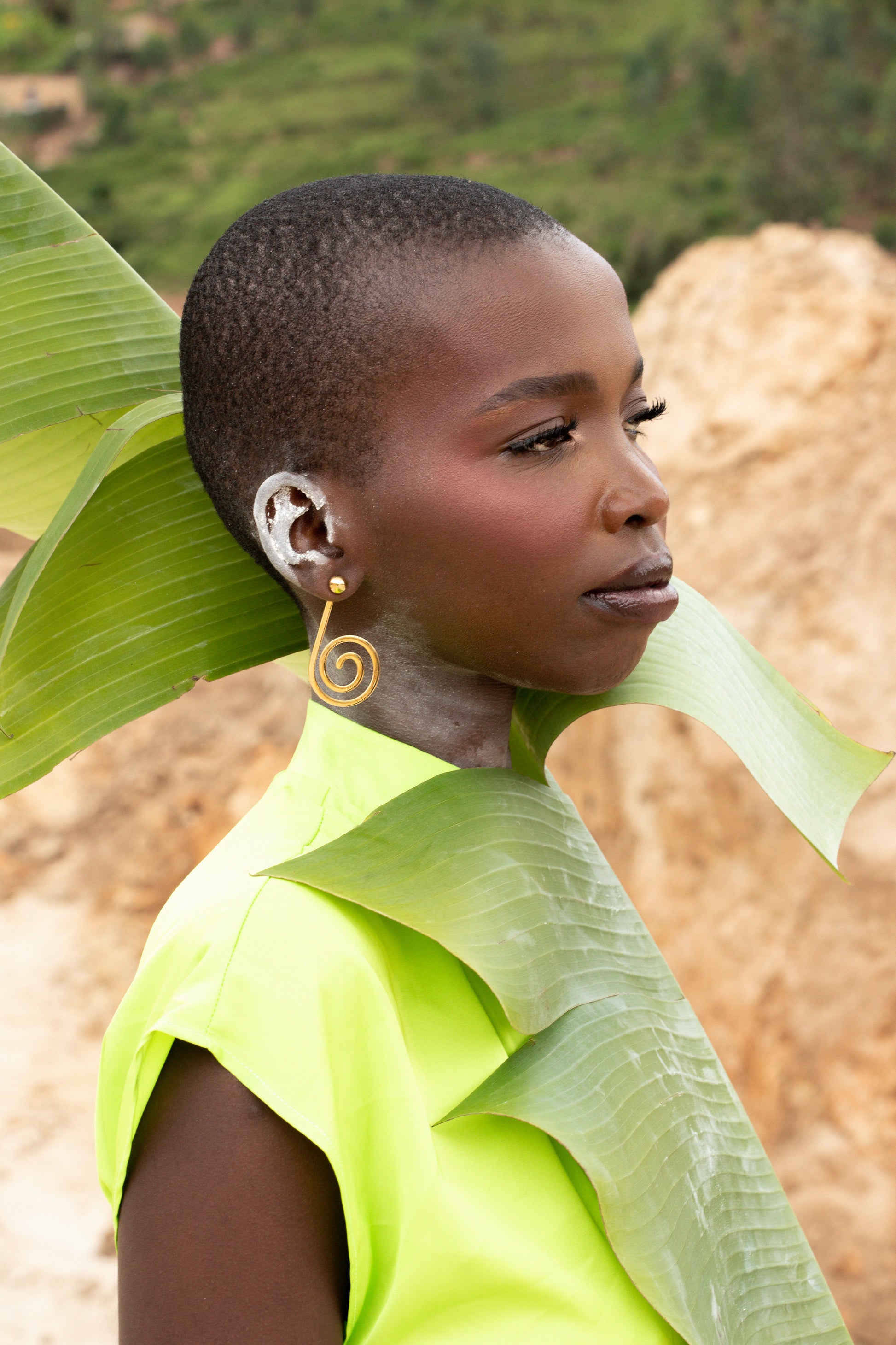 A black model wearing Zvet gold plated earrings